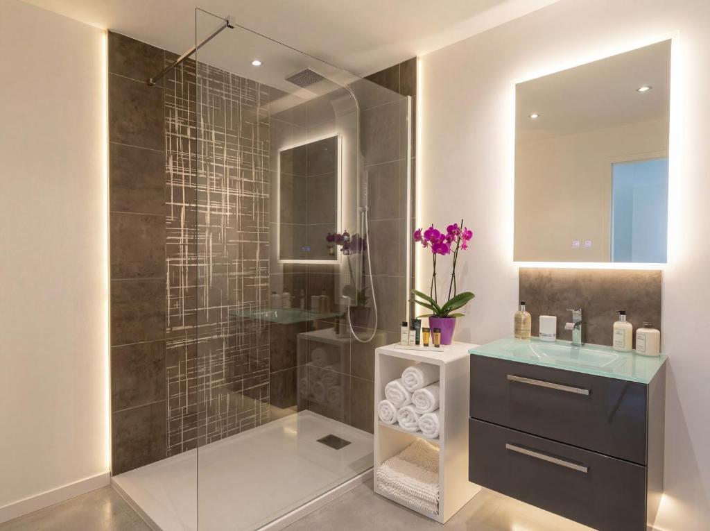 a bathroom with a glass shower and a sink at La Roche aux Fées in Lapte