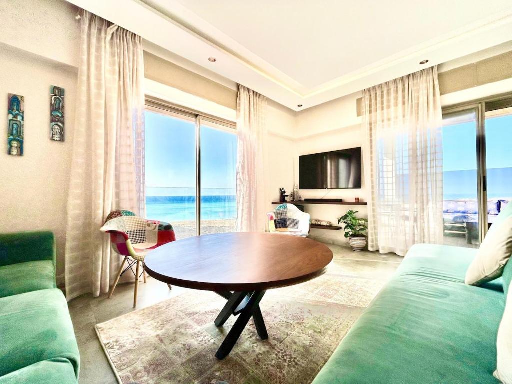 a living room with a couch and a table with a view at 360 Oceanfront & Sunset View Condo - Terrace & 2BR in Tangier