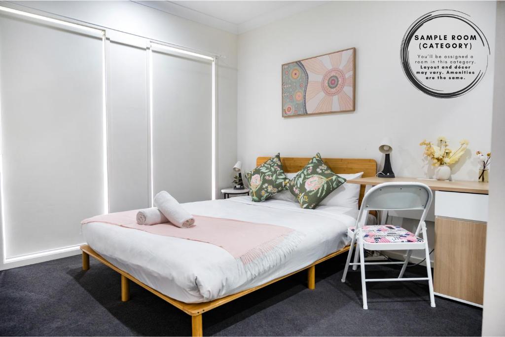a bedroom with a bed with a desk and a chair at Standard Queen Room in Gregory Hills - Quaint Spot - Shared Bathroom in Gledswood Hills