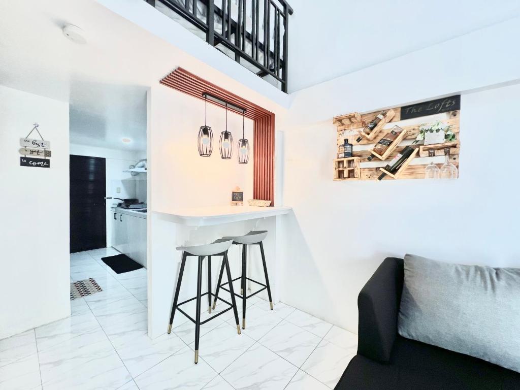 a kitchen and living room with a bar and stools at 2 Beds Spacious Centrally Located Loft Apartment in Naga