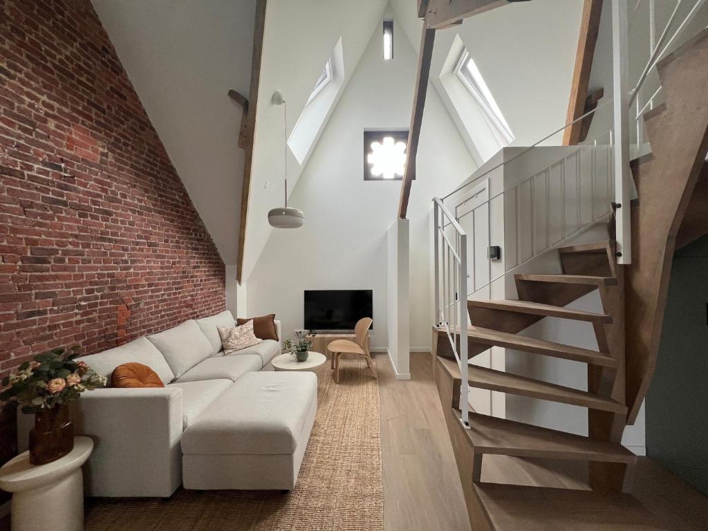 a living room with a white couch and a brick wall at Inviting apartment in Bree with terrace in Bree