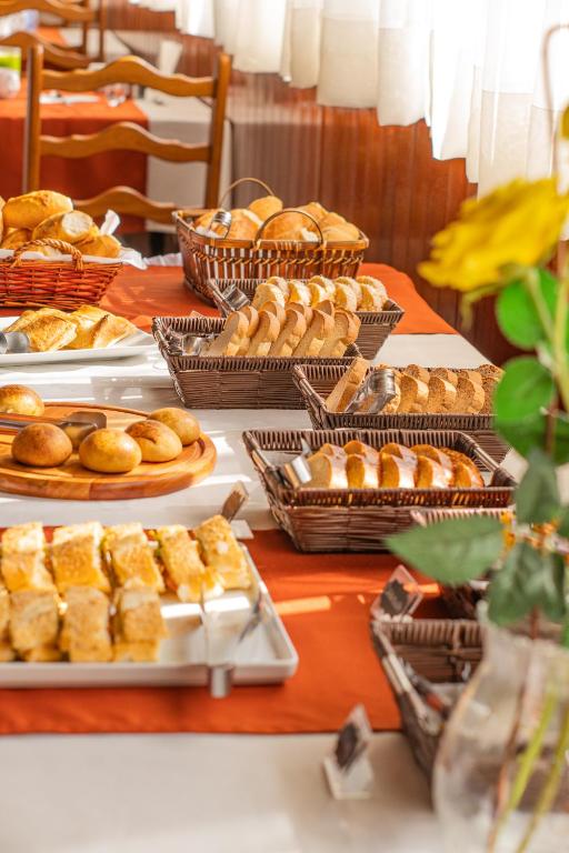 una mesa cubierta con diferentes tipos de pan y pasteles en Hotel Ascona, en Campos do Jordão