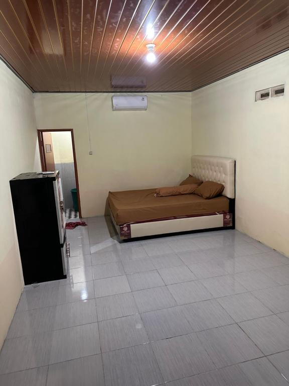 a bedroom with a bed in the corner of a room at Homestay Joglo Kembar in Gading