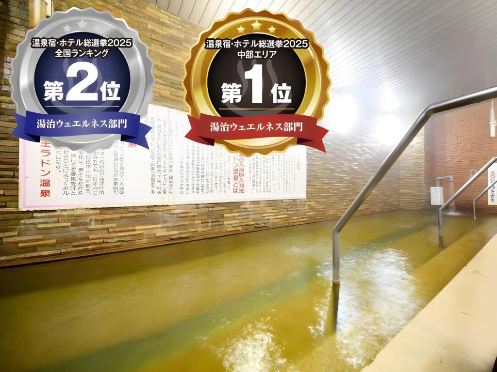 two signs in a flooded room with water at 吸う温泉 湯治の宿 竜王ラドン温泉 湯ーとぴあ in Kai