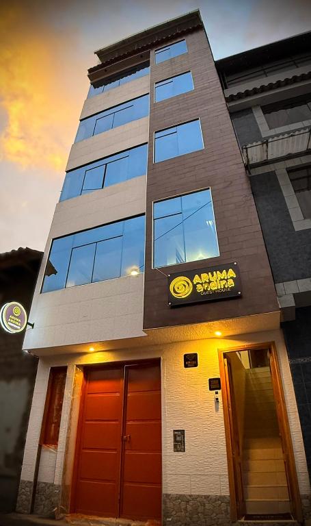 a building with a sign on the side of it at Aruma Andina Hotel CHAVÍN in Chavín de Huantar