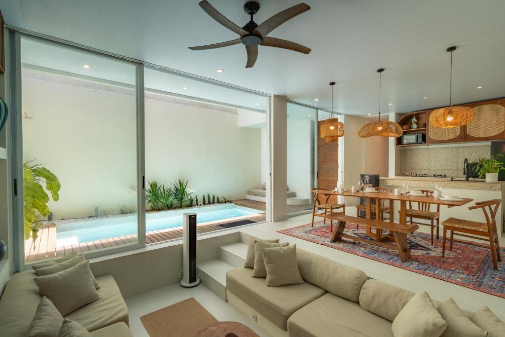 a living room with a couch and a dining room at SandWave Villa by Betterplace in Ungasan