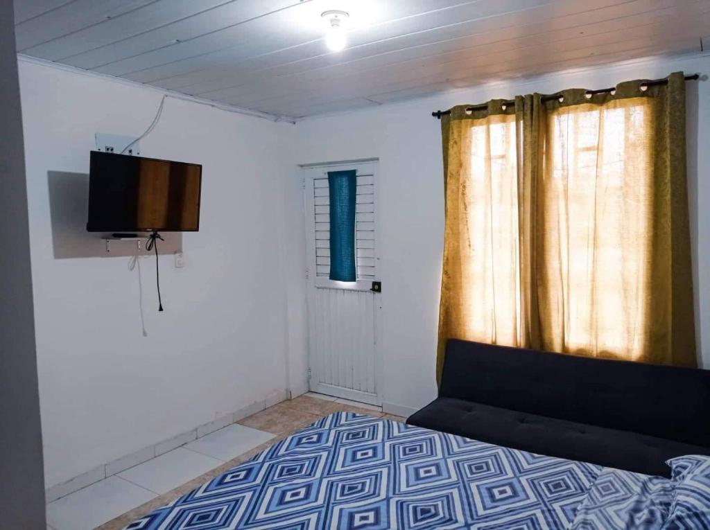 a room with a bed and a tv and a window at Sweetroom Miss Gloria in Estación El Salto