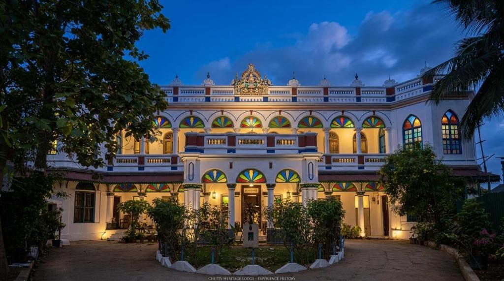 a large building at night with its lights on at Chettinadu Mansion – An Authentic Heritage Palace in Kānādukāttān