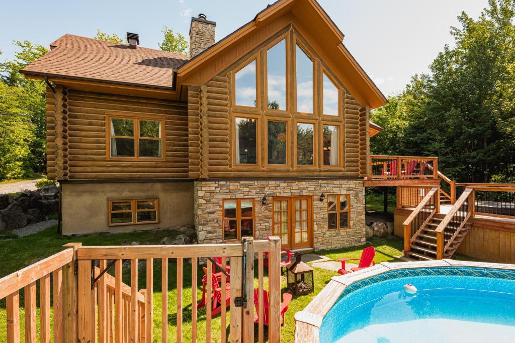 a log home with a pool and a house at Fiddler Lake Resort - Deer 68 in Mille-Isles