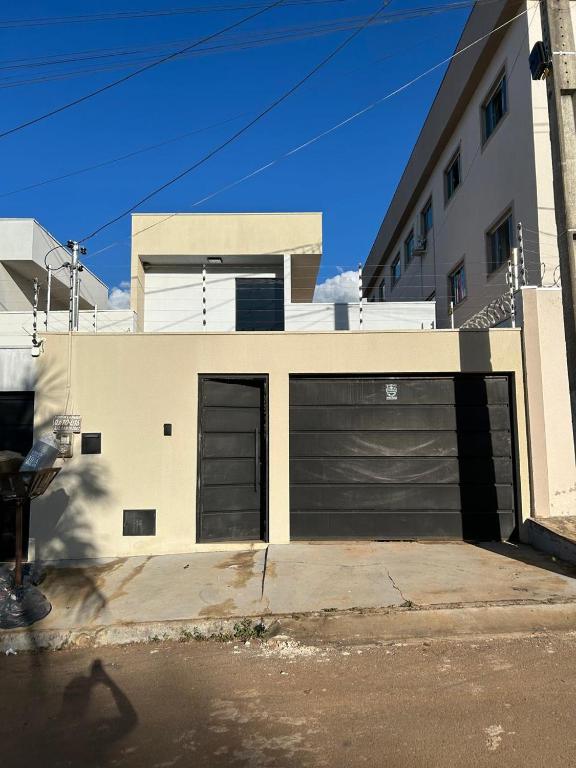 a house with two garage doors on a street at Casa com 3 quartos aconchegante in Anápolis