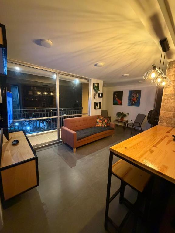 a living room with a couch and a large window at Comodidad, sol y descanso total in Melgar