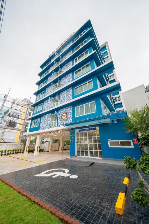 a blue building with a handicapped sign in front of it at DF Hotel Pattaya in Pattaya South