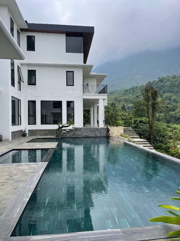 a swimming pool in front of a house at emoi valley bavi in Ba Vì