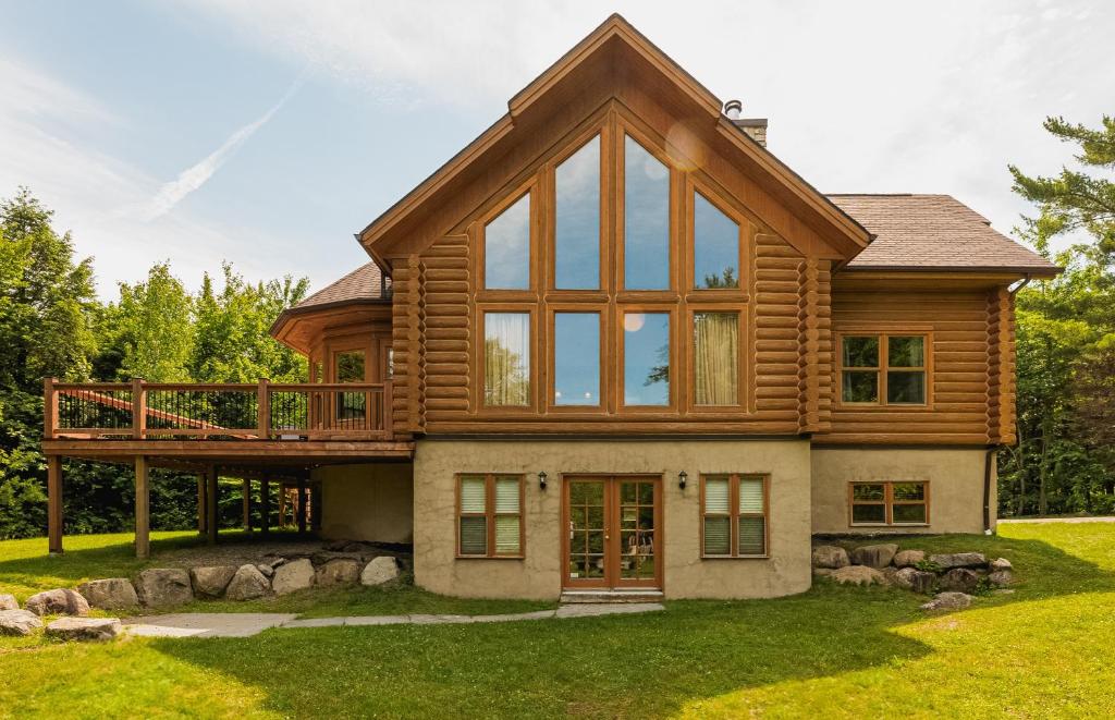 a wooden house with a balcony on top at Fiddler Lake Resort - Deer 69 in Mille-Isles