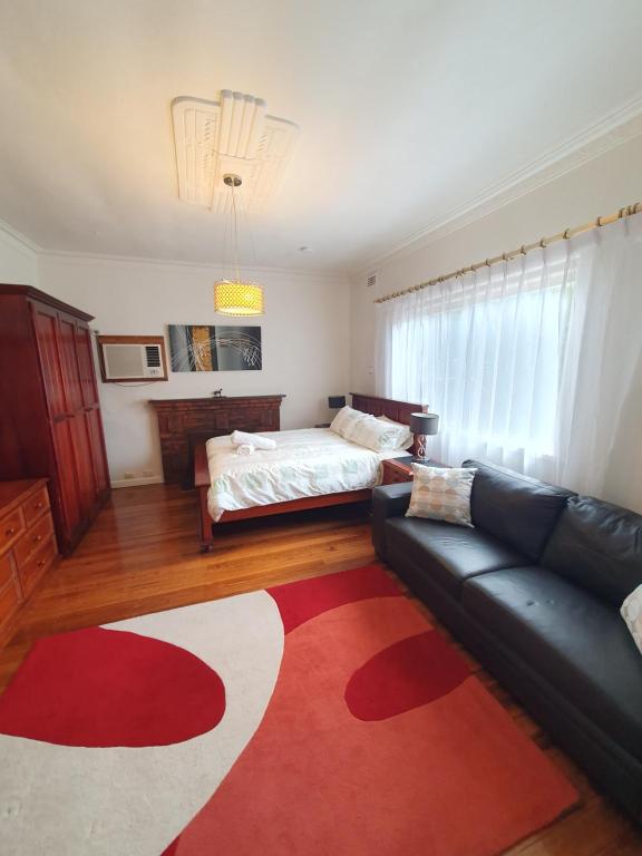 a living room with a couch and a bed at Sunbury Central in Sunbury