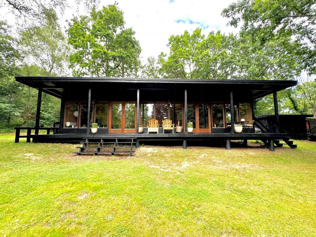 a pavilion in a park with benches in the grass at Architectural Cottage On 7000 Sqm Nature Plot in Hadsund