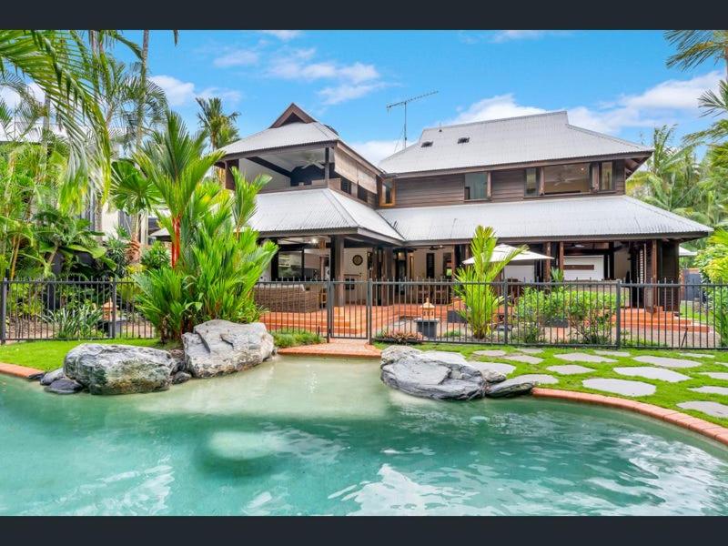 a house with a swimming pool in front of a house at Solander Beachfront with private beach access & pool in Port Douglas