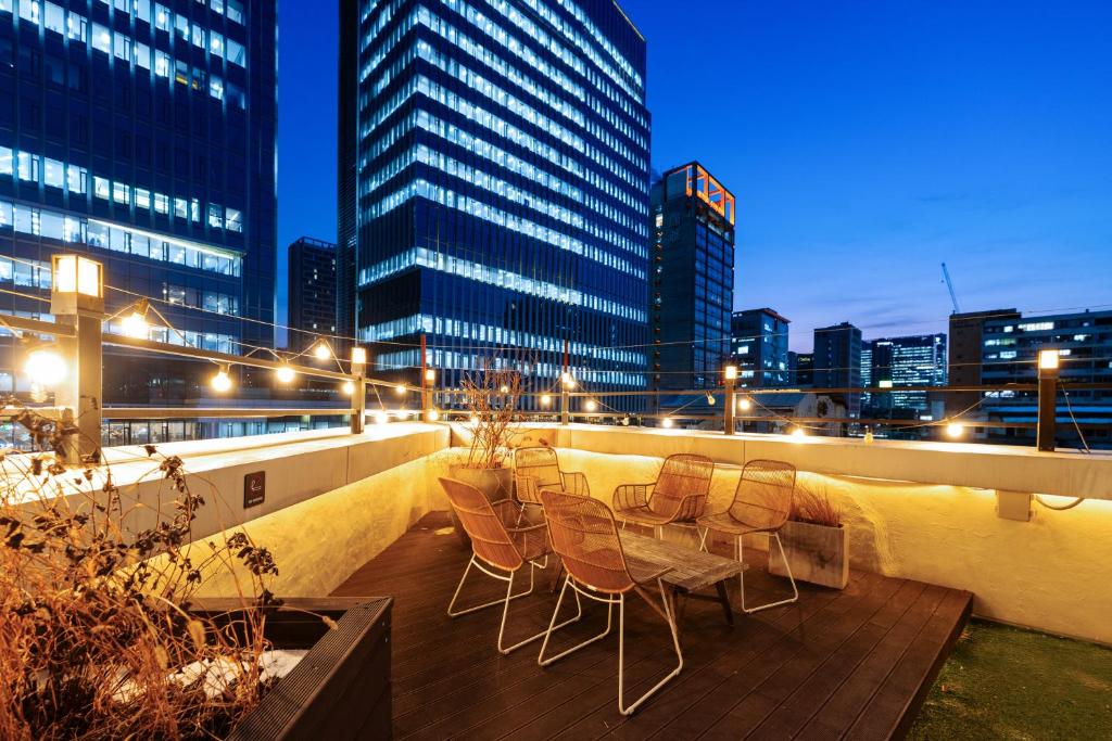 a group of chairs on a boardwalk in a city at night at MONTHLIV Euljiro Hotel Stay in Seoul