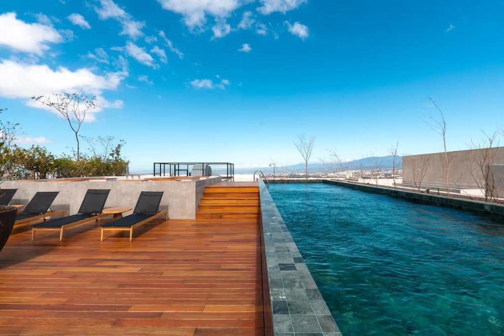 a swimming pool with chairs on top of a building at Babylon Prime Nunciatura in San José