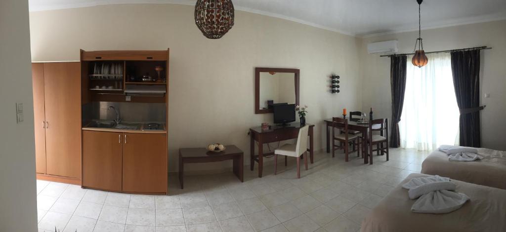 a living room with a bed and a kitchen with a table at Kalloni Royal Resort in Kalloni