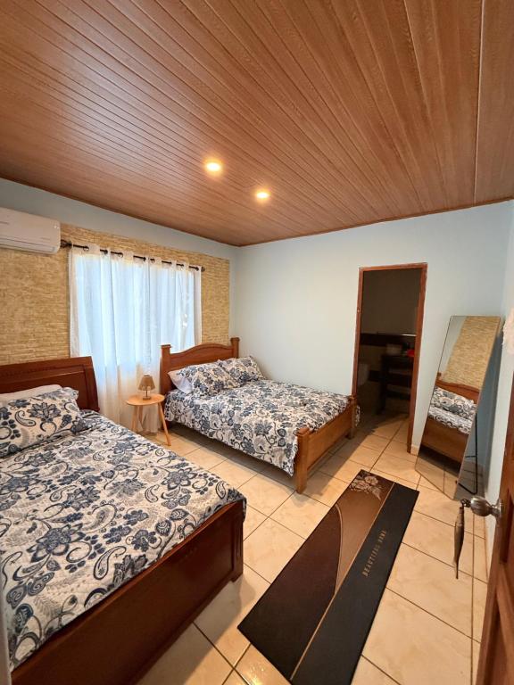 a hotel room with two beds and a mirror at BREEZE Hostal Boca Chica in Boca Chica