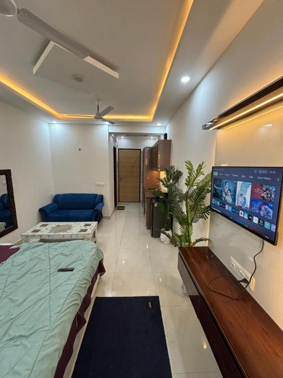 a living room with a bed and a flat screen tv at isuites in Ghaziabad