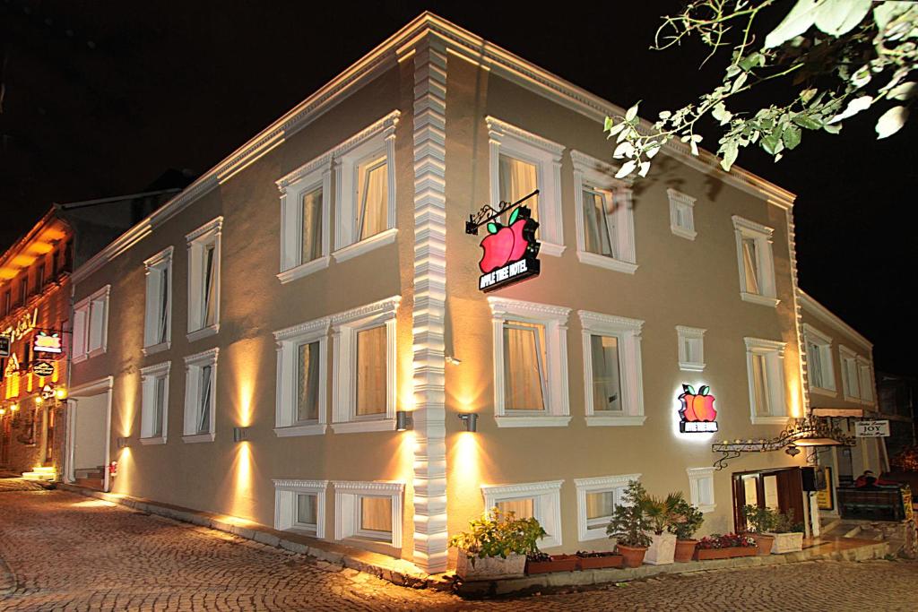 a large white building with a sign on the side of it at Apple Tree Hotel in Istanbul