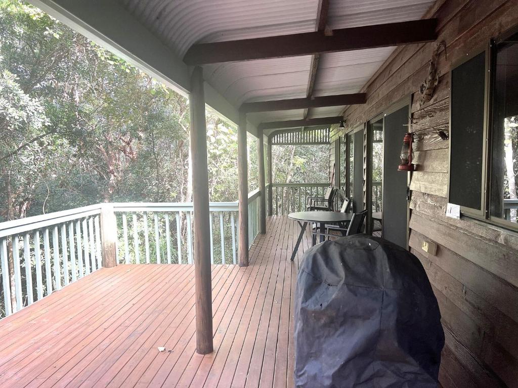a screened in porch with a table and chairs on it at For Rest at Crescent Head in Crescent Head