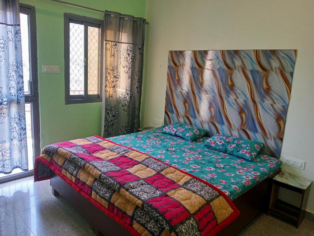a bedroom with a bed with a colorful comforter at Krishna Hotel & Restaurant in Devaprayāg
