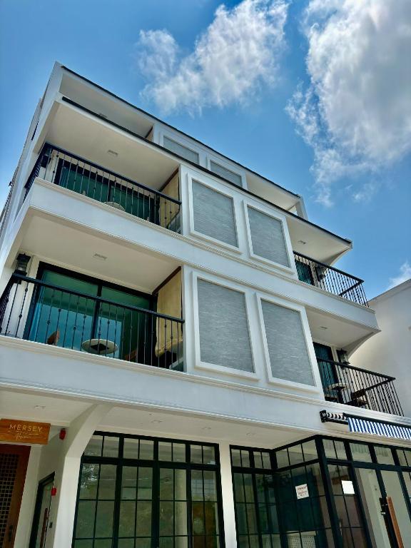 a white building with balconies on top of it at Mersey Residence Koh Samui in Lamai
