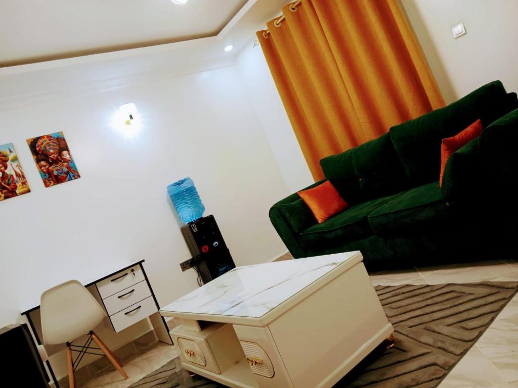 a living room with a green couch and a table at HomePlug Realty in Ongata Rongai 