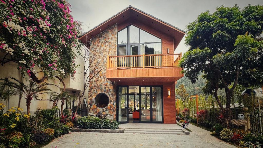 a house with a balcony on top of it at Anvi Haven in Sóc Sơn