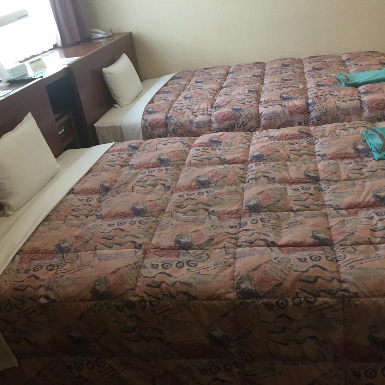 Postel nebo postele na pokoji v ubytování Hotel Niihama Hills