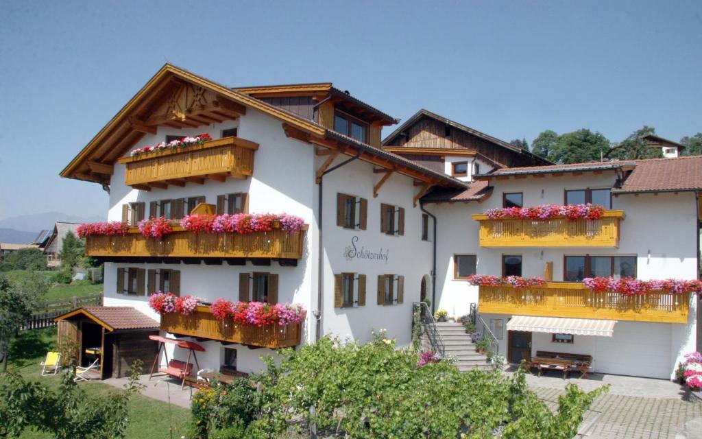 un gran edificio blanco con flores en los balcones en Schötzerhof, en Meltina