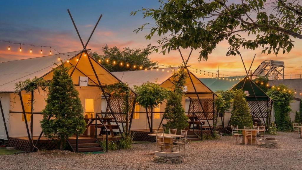 a group of tents with tables and chairs in front at Chaesonghwa Glamping in Yeongcheon in Yeongcheon