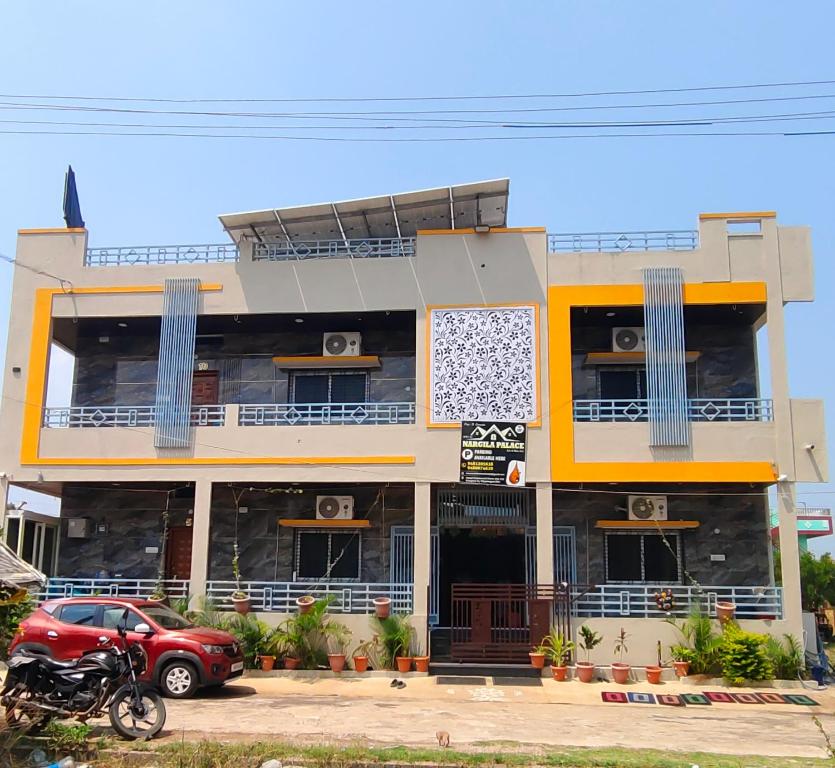 a red car parked in front of a building at NARGILA HAMPi in Hampi