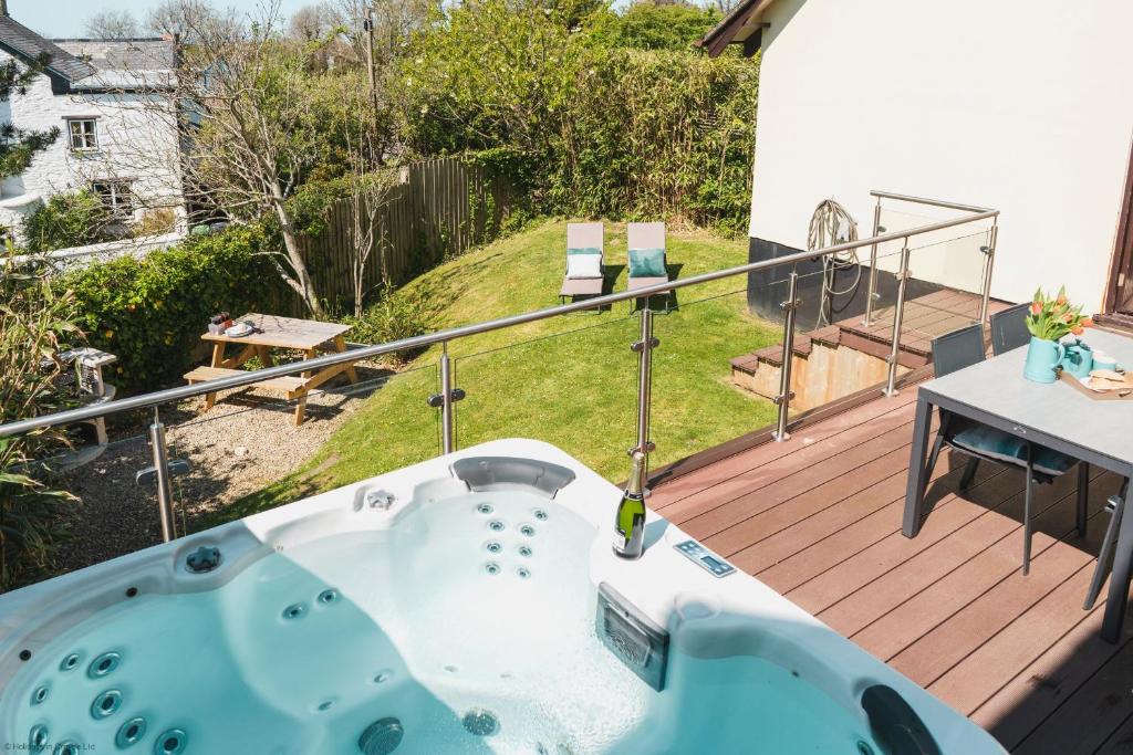 a jacuzzi tub on the deck of a house at Driftwood in Croyde