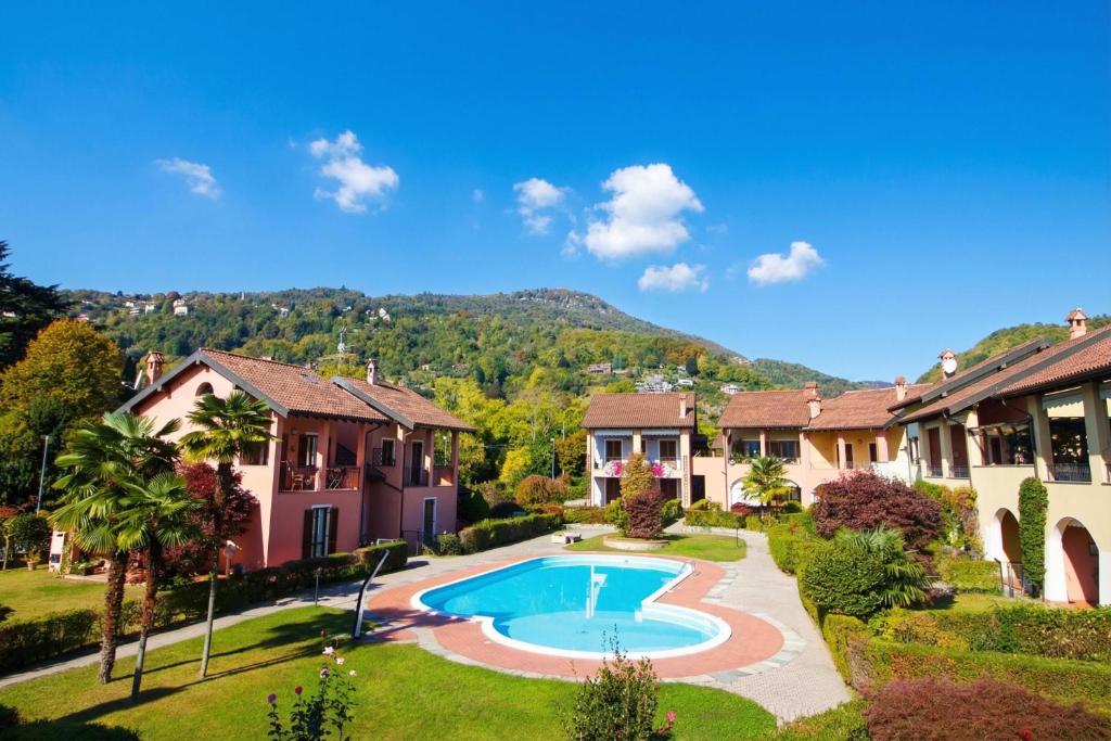 a house with a swimming pool in a yard at Sunflower - Lake Maggiore Duplex w/ Terrace and Shared Pool in Lesa