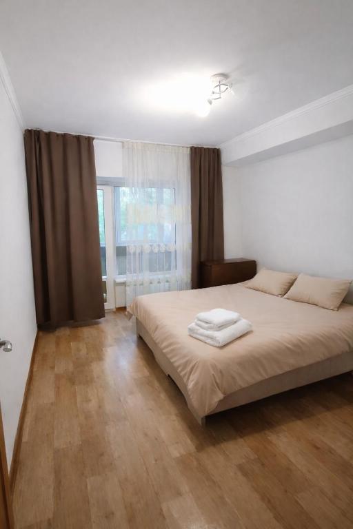 a bedroom with a bed with two towels on it at Апартамент возле аэропорта in Almaty