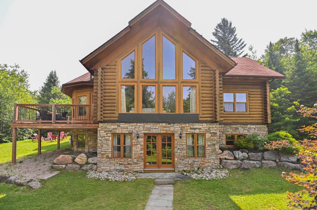 a log cabin with a deck and a house at Fiddler Lake Resort - Deer 86 in Mille-Isles
