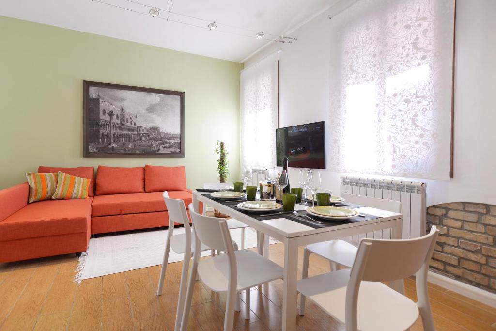 a living room with a table and a red couch at Venice Murano Flat in Murano