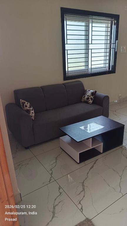 a living room with a couch and a table at Suneetha Presidency in Amalāpuram
