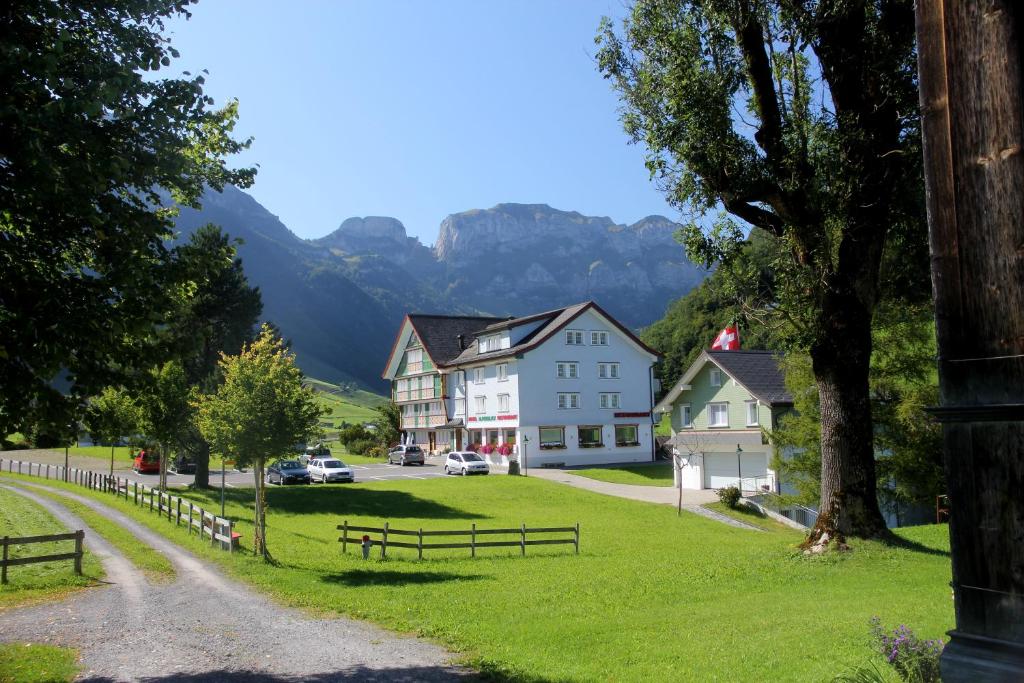 a village in the mountains with a road and houses at Hotel Alpenblick in Weissbad