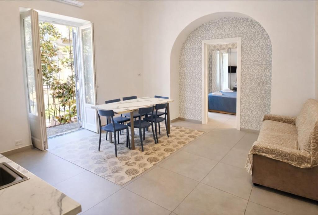 a living room with a table and chairs and a couch at Corso Vittorio Elegant Suites Lipari in Lipari