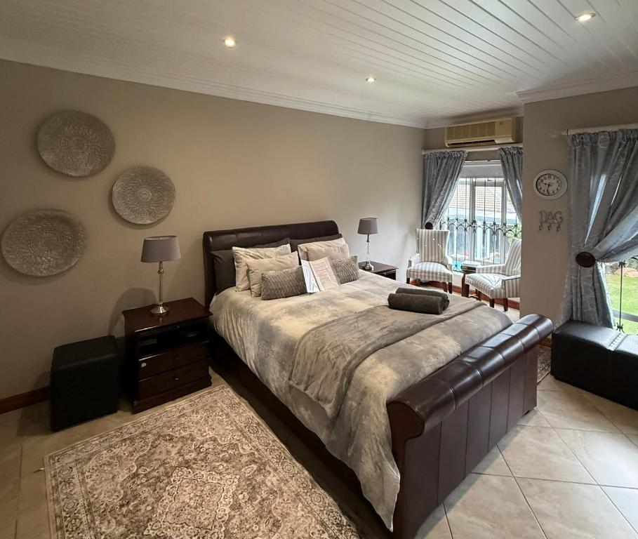 a bedroom with a large bed and a couch at ARK Guesthouse in Potchefstroom