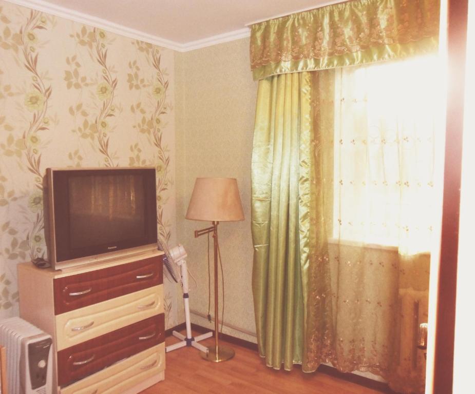 a living room with a television and a window at Ахметова 10 in Krasnoye Pole