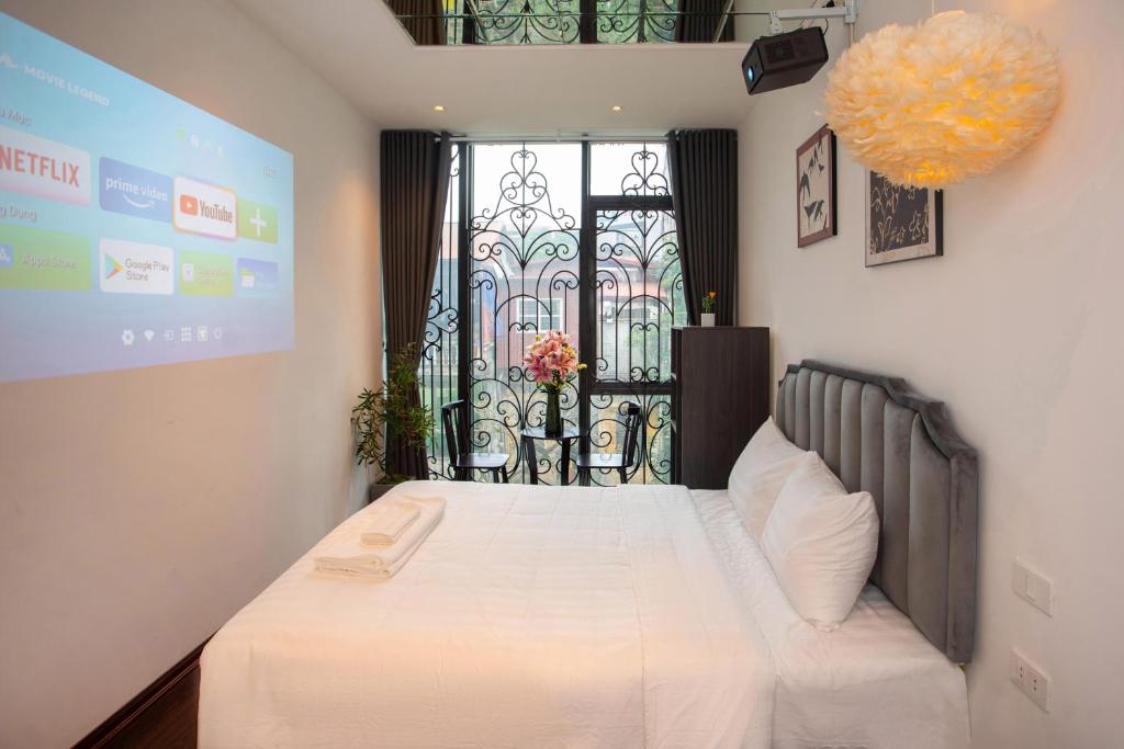 a bedroom with a bed and a screen with a window at Luma Boutique Hotel in Hanoi