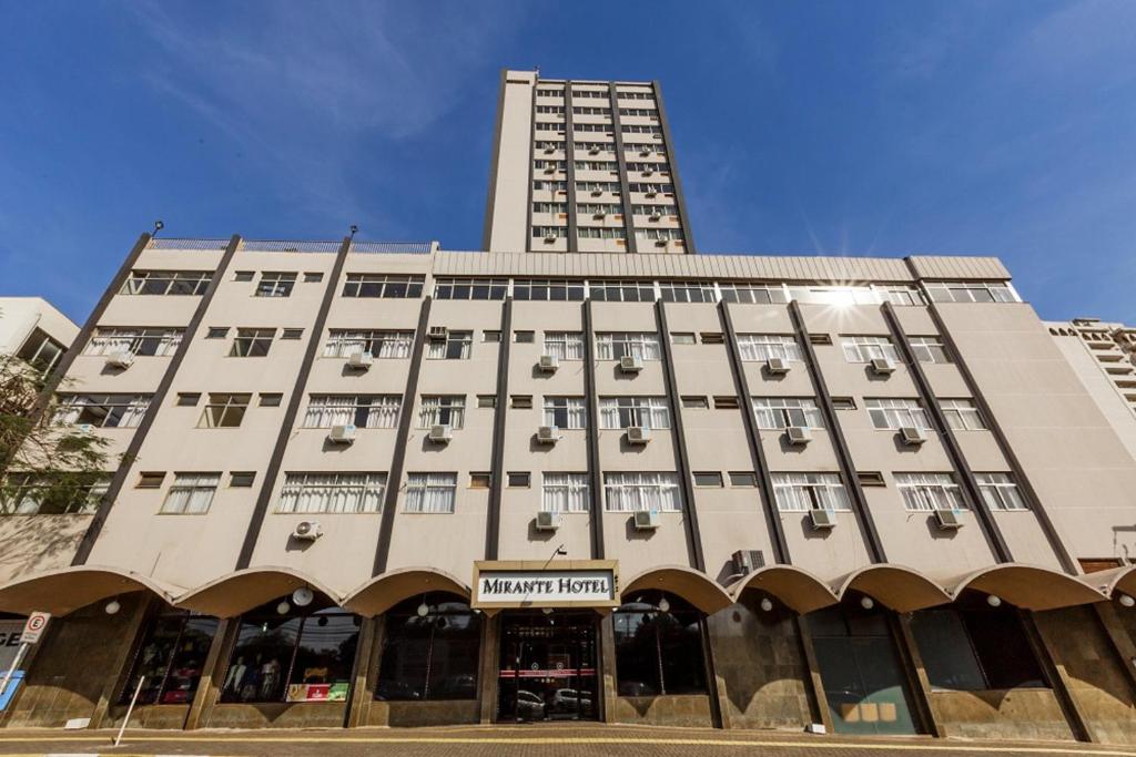 a large white building with a tall building at Mirante Hotel in Foz do Iguaçu