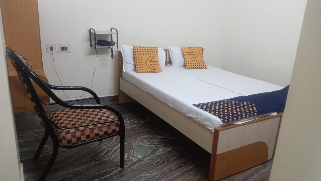 a bed and a chair in a room at Le Palace in Gūduvāncheri