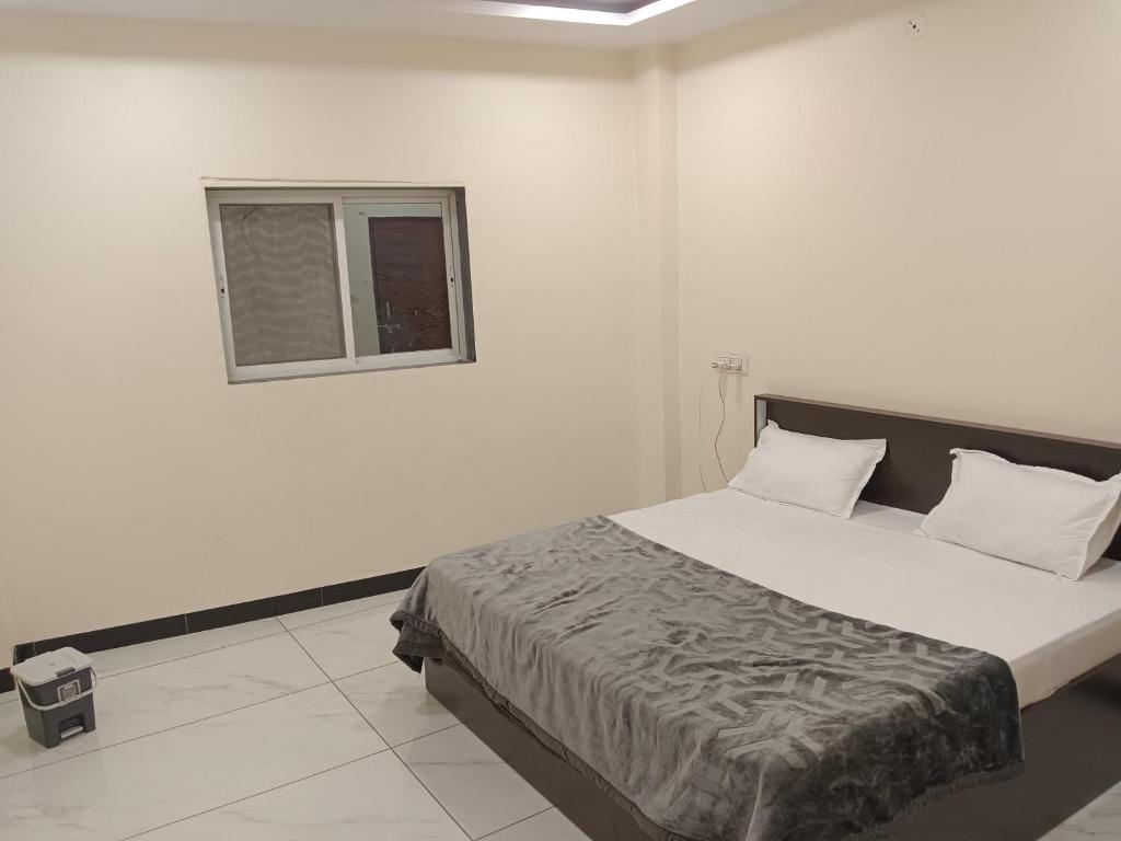 a bedroom with a large bed with a window at Hotel Bhagwati Palace in Ujjain